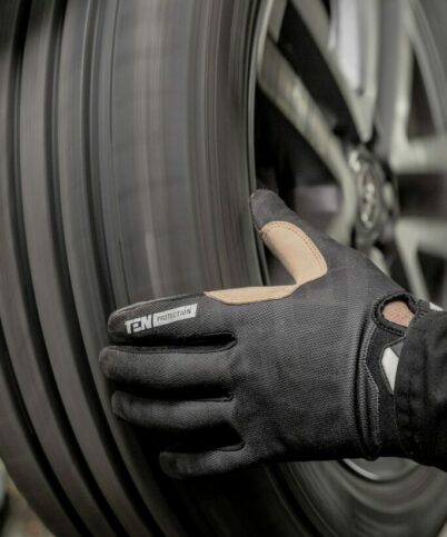 a close up of a person wearing a glove on a tire
